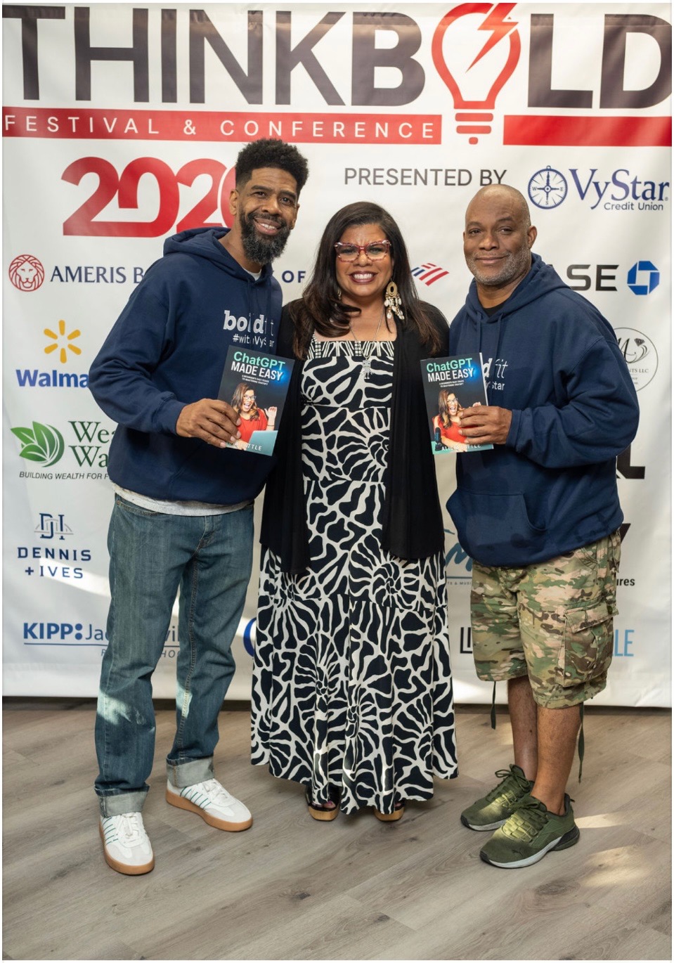 Troy and Mo with a guest in front of the ThinkBold Festival & Conference backdrop presented by VyStar Credit Union