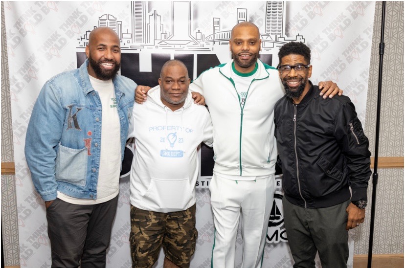 Troy and Mo standing with two guests in front of the Think Bold Festival & Conference backdrop
