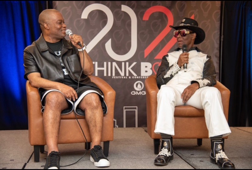 Mo on the festival stage in the armchair conversation, seated across from a guest