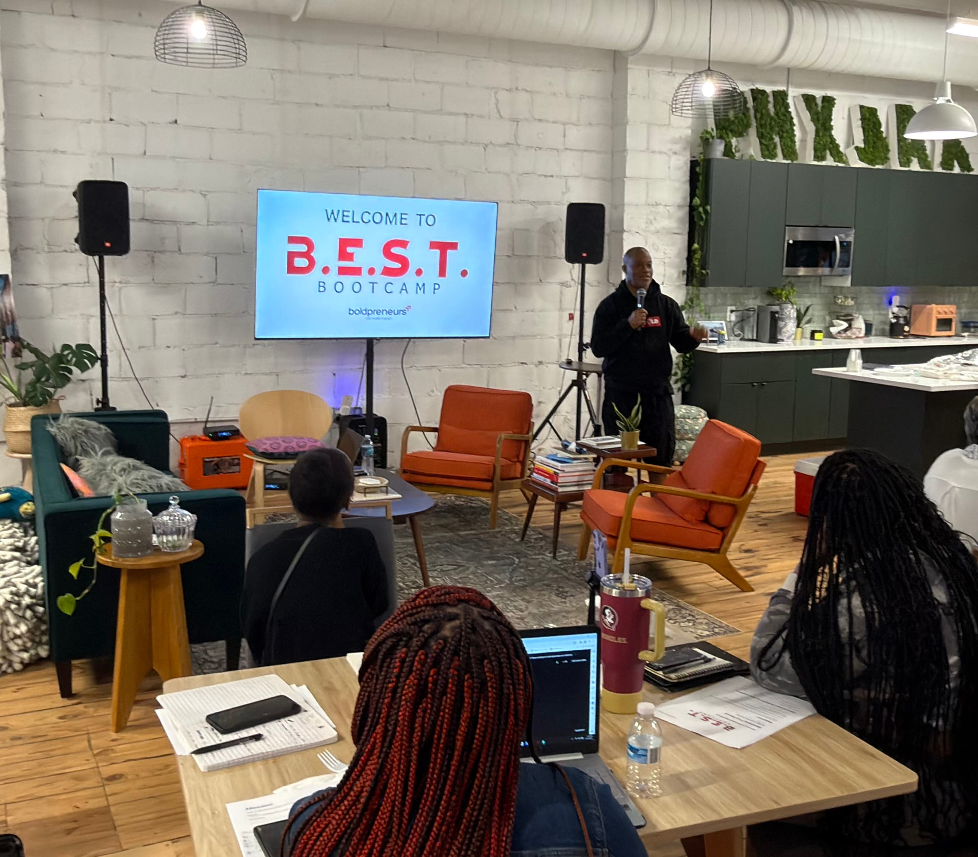 Mo speaking with a microphone at B.E.S.T. Bootcamp in the loft studio