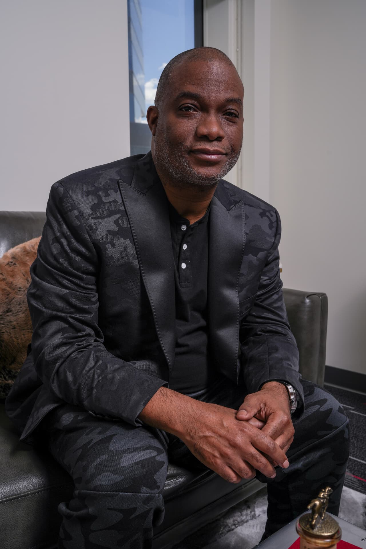 Troy McNair Sr., portrait in a black camo suit in the boardroom